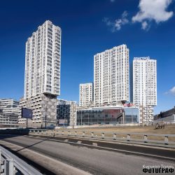 Фотограф Кирилл Толль. Утилитарный прагматизм внешней отделки из фиброцемента корпусов придорожной линии застройки . Архитектурная съемка брутального фасада здания с характерными накладными балконами